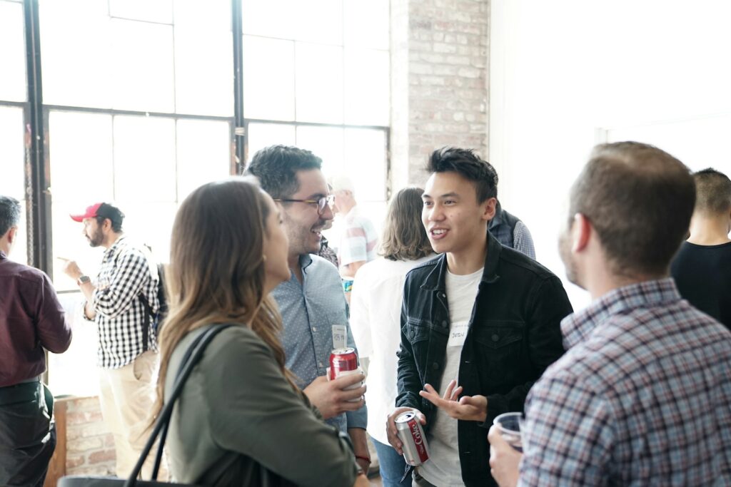 People chatting and smiling together in an open lobby after an event