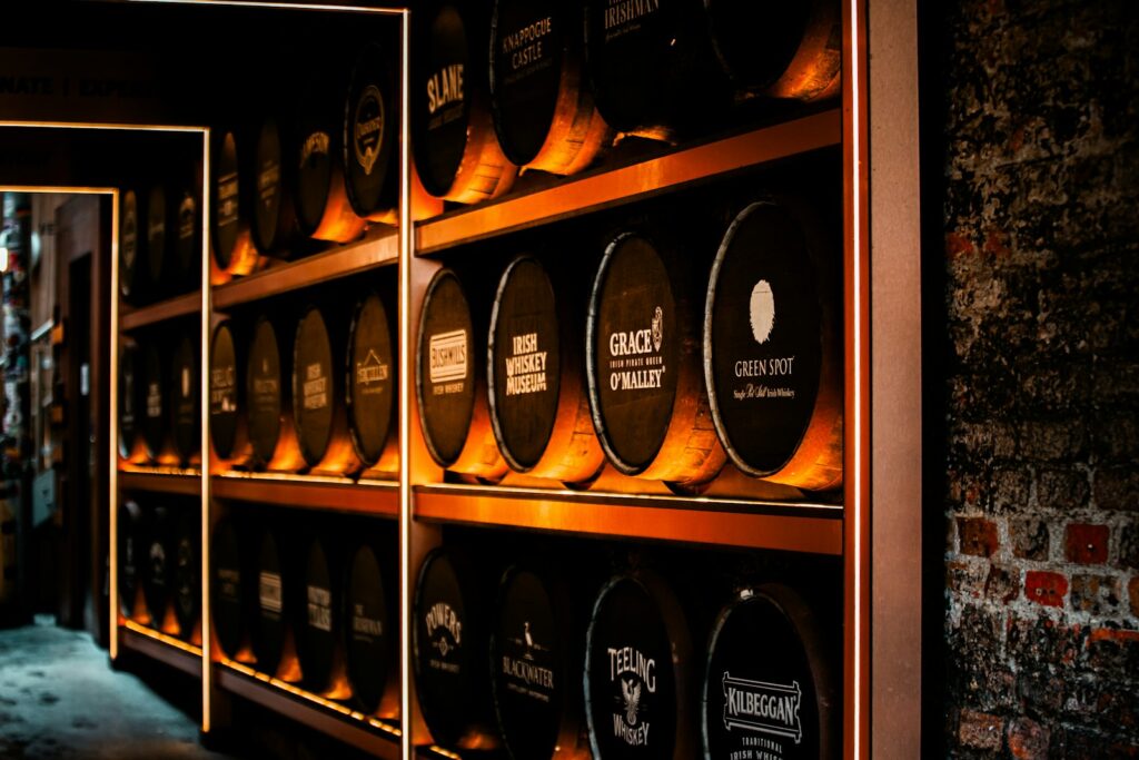 Rows of whiskey barrels stacked on shelves in a cellar