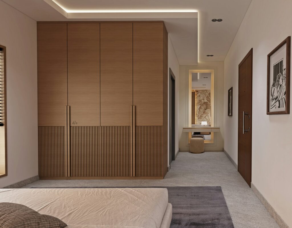 Modern bedroom with large wooden wardrobes and a vanity area, showing a finished fitted look