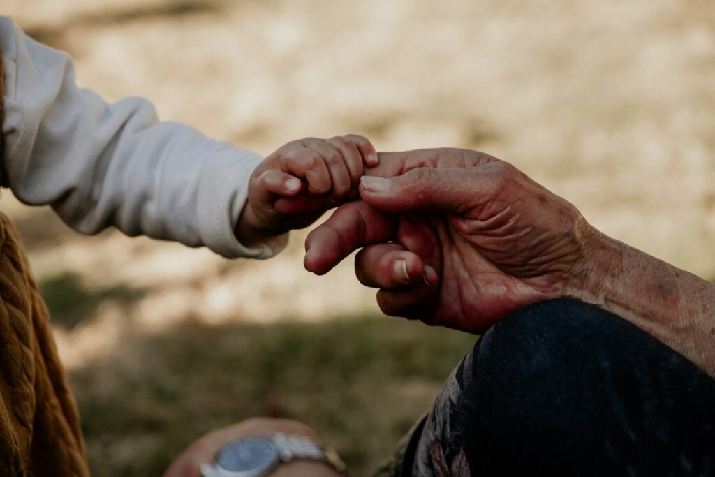 Grandmother and young grandchild holding hands, a gentle moment of family connection like a contact visit