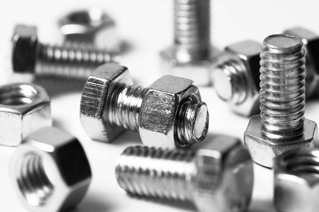 Close-up of scattered nuts and bolts on a white background